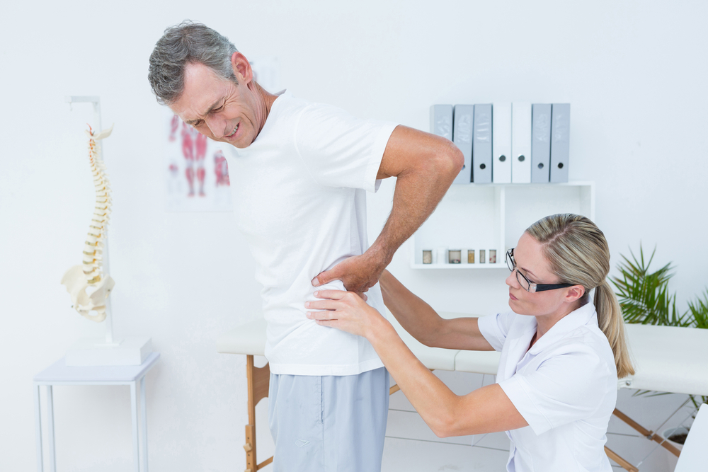 Doctor examining her patients back